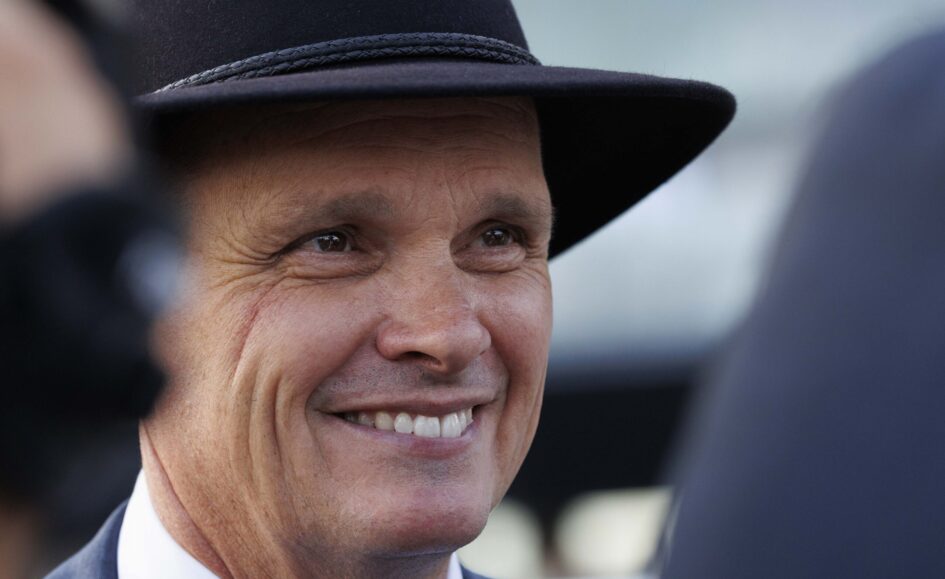 Close-up of a smiling man wearing a black hat, cropped portrait.