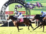 Two jockeys race on thoroughbreds near a decorative arch at Eagle Farm, with Ladbrokes banners in the background.