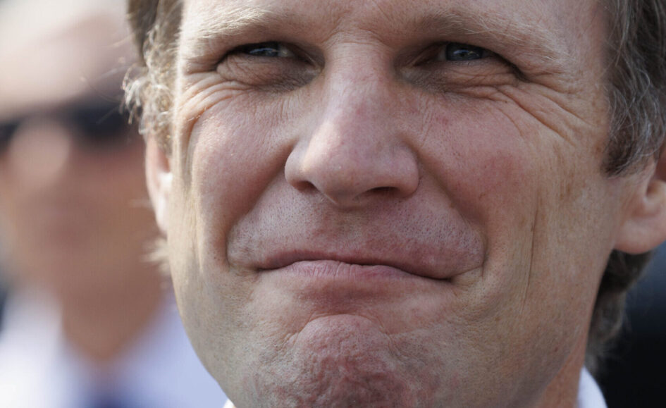 Close-up of a middle-aged man's face with a subtle smile, showing wrinkles around eyes and mouth.